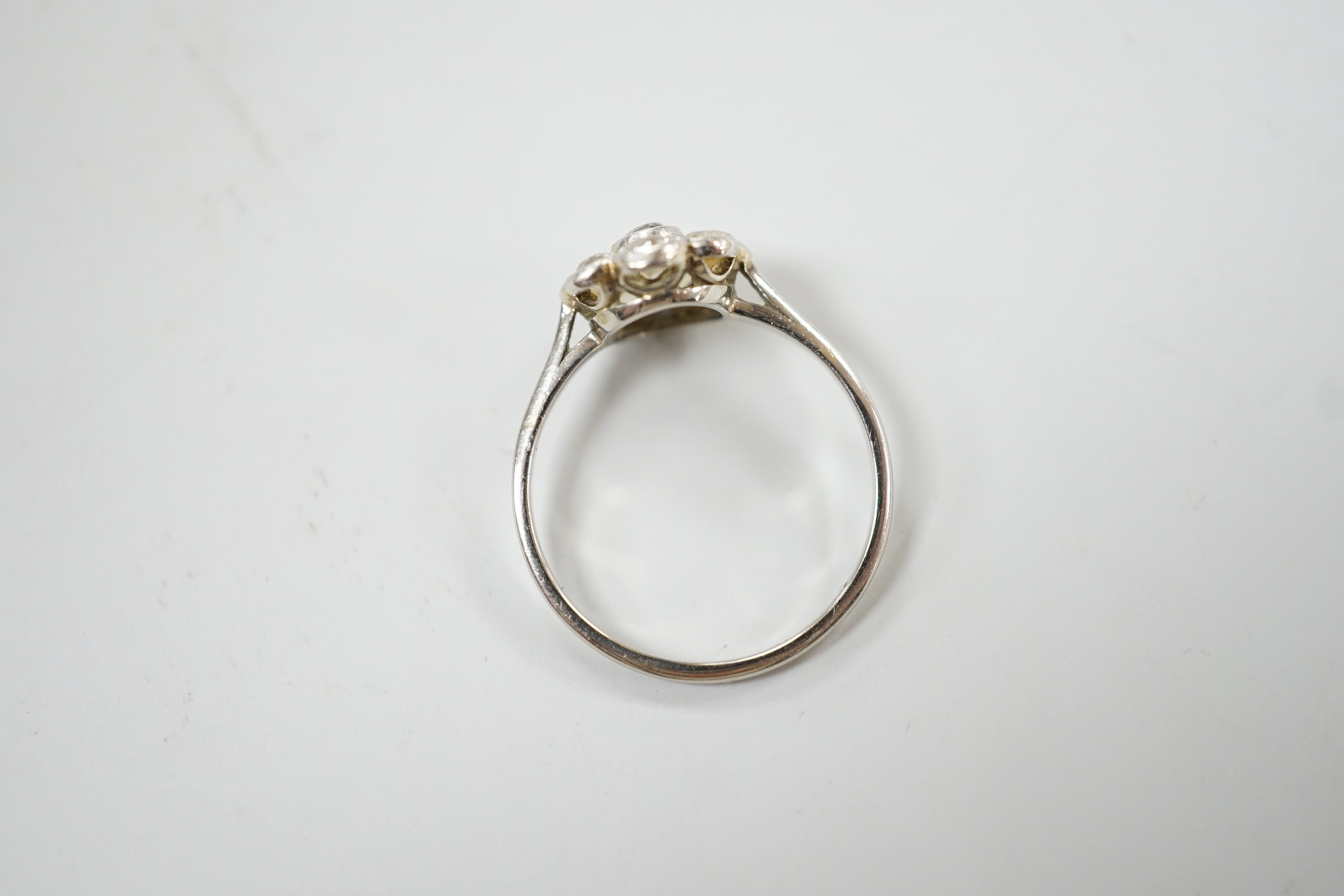 A 1920's 18ct, plat and millegrain set diamond flower head cluster ring, size O, gross weight 2.2 grams.